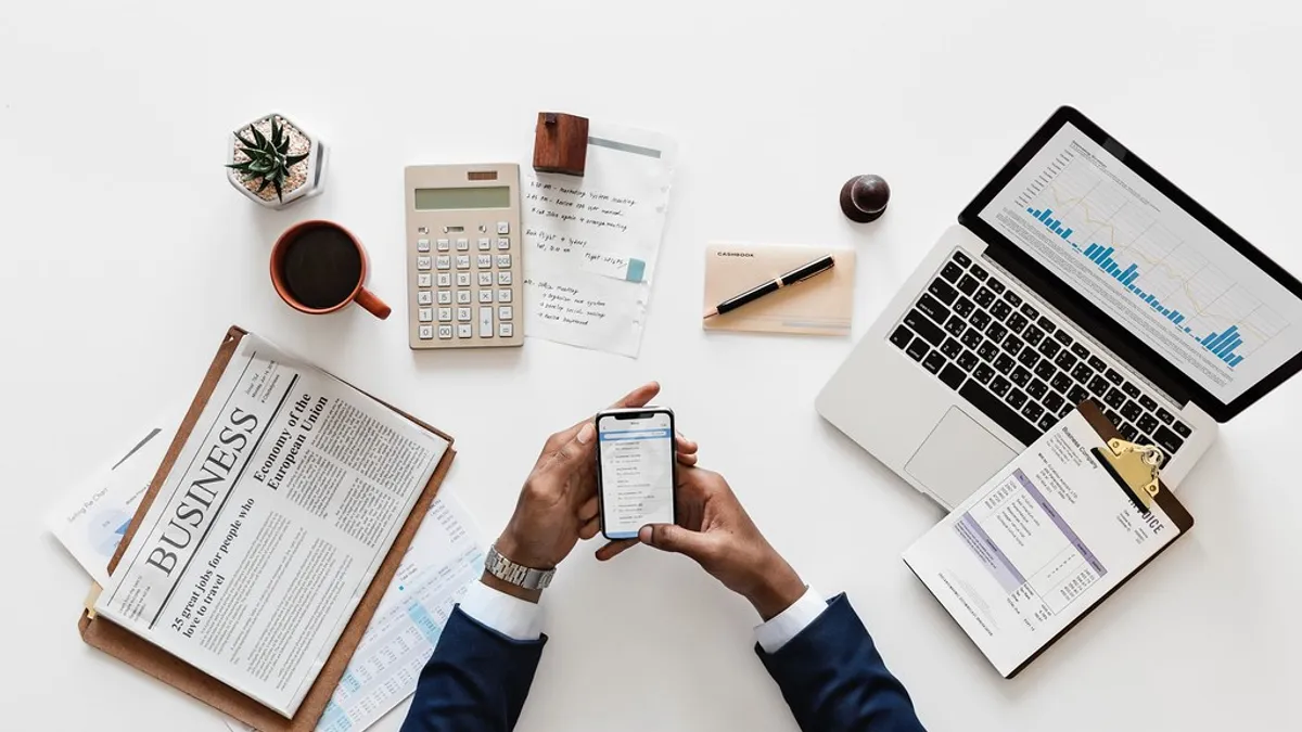 Is een bestelbusverzekering btw-aftrekbaar? Zakelijk bureau met rekenmachine, laptop en financiële documenten
