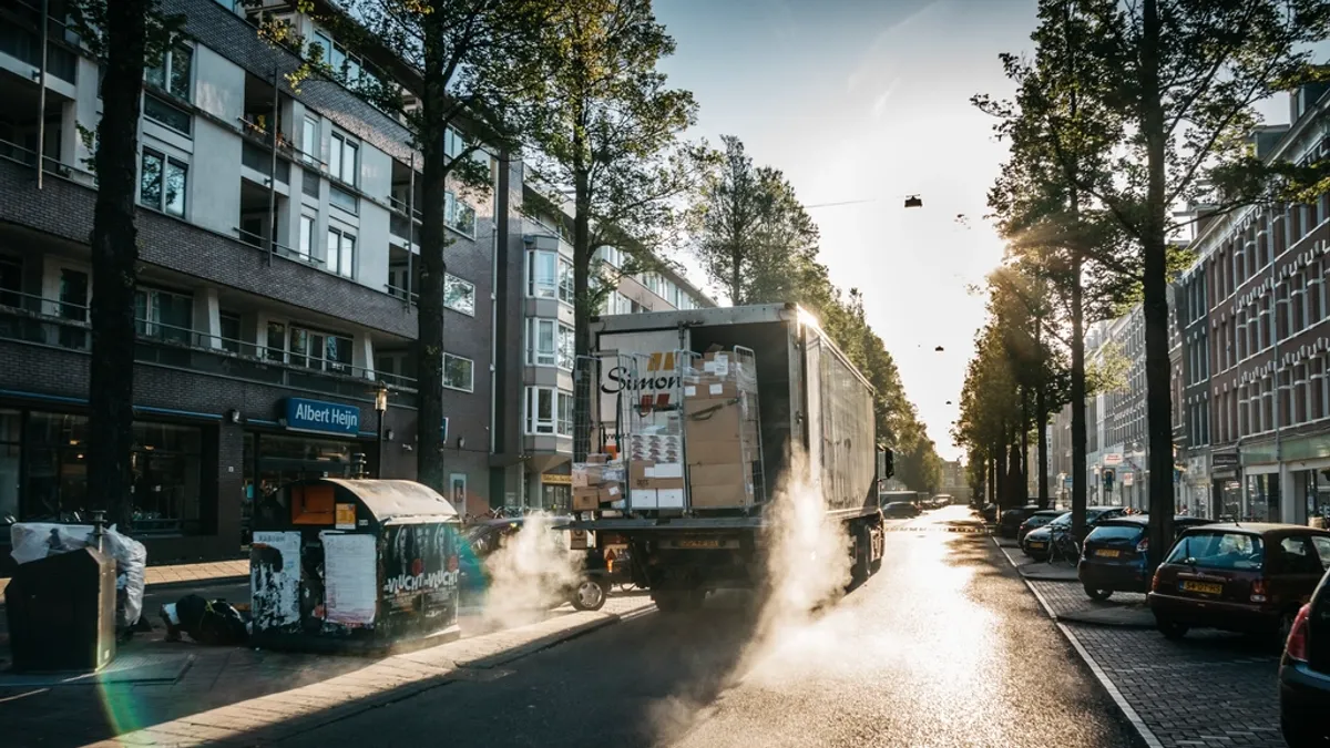 Dagwaarde, nieuwwaarde of aanschafwaarde bij schade aan je bedrijfswagen Bedrijfswagen rijdt door een natte stadsstraat